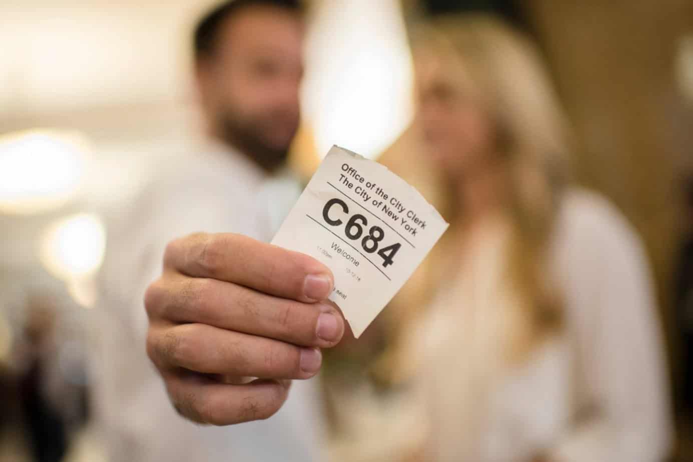 couple holding a marriage ticket at city hall in nyc