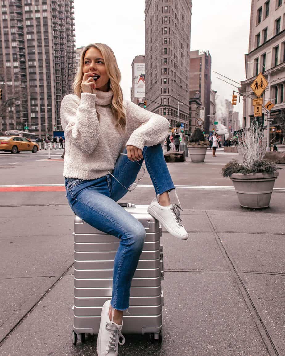 white sneaker outfit with blue jeans and a turtleneck sweater