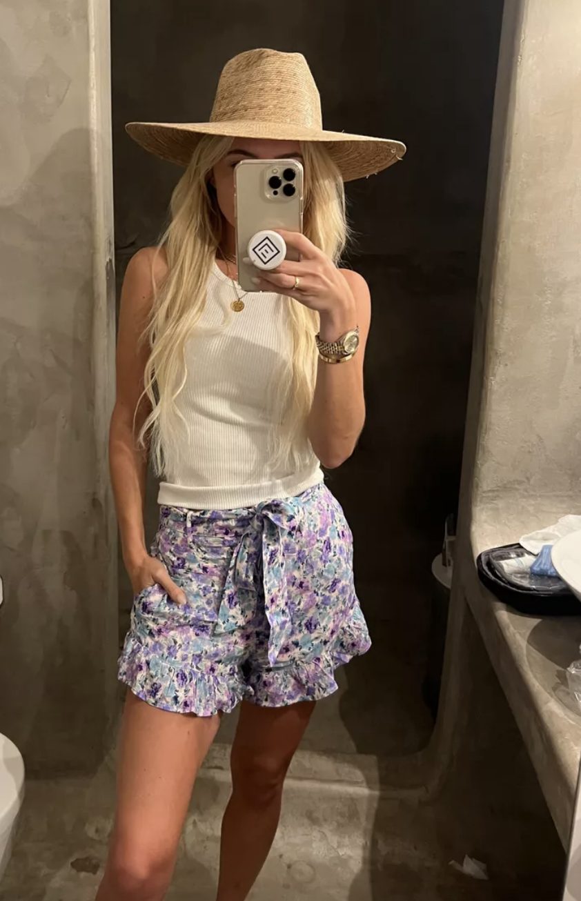 floral shorts with a white tank and a straw hat